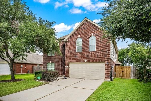15323 Southwood Trace Ln, Houston, TX 77049 - traditional-style house featuring brick siding, driveway, and an attached garage