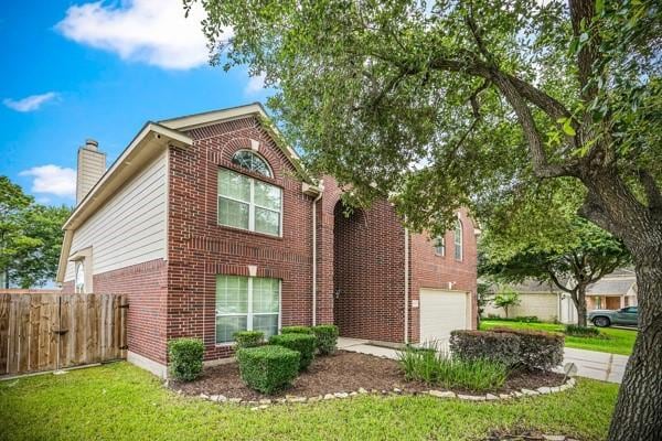 15323 Southwood Trace Ln, Houston, TX 77049 - view of front of property featuring brick siding, a garage, driveway, and a chimney