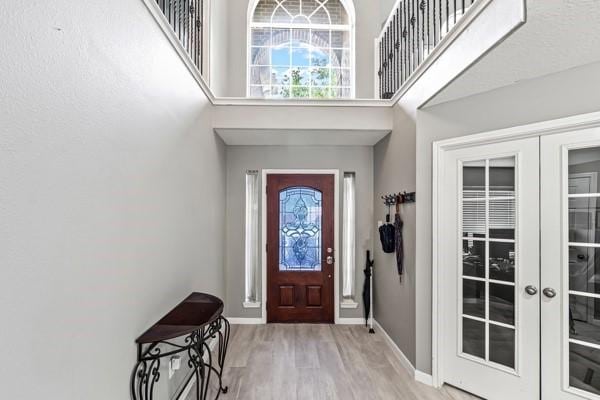15323 Southwood Trace Ln, Houston, TX 77049 - entrance foyer with french doors, healthy amount of natural light, a towering ceiling, and wood finished floors
