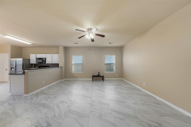 17415 Blackstone Trails Dr, Humble, TX 77396 - kitchen featuring stainless steel fridge, black microwave, light marble finish floors, and a ceiling fan