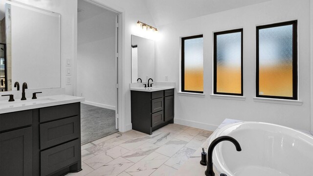 7246 Monarch Dr, Katy, TX 77493 - full bath featuring marble look tiles, two vanities, and a tub to relax in