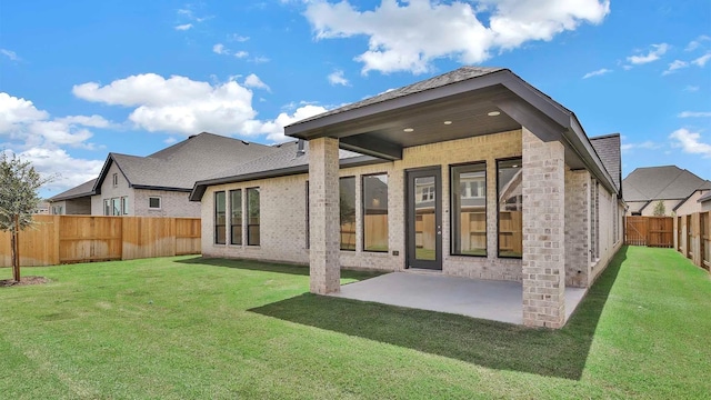 7246 Monarch Dr, Katy, TX 77493 - back of property featuring a fenced backyard, a patio area, brick siding, and a shingled roof