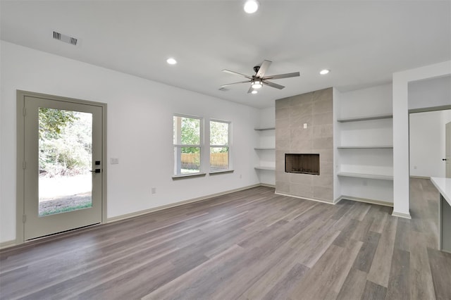 4 Hanover Ln, Panorama Village, TX 77304 - unfurnished living room with recessed lighting, a ceiling fan, wood finished floors, built in shelves, and a fireplace