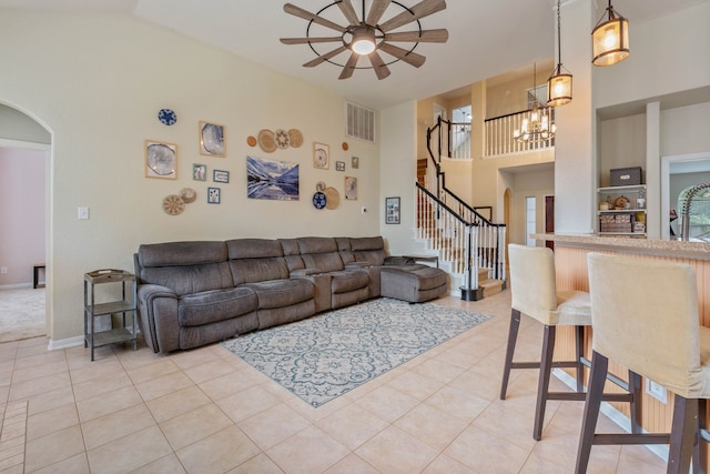 23 Murmuring Creek Pl, The Woodlands, TX 77385 - living room featuring arched walkways, a ceiling fan, stairs, light tile patterned floors, and a chandelier