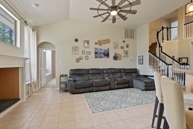 23 Murmuring Creek Pl, The Woodlands, TX 77385 - living room featuring a ceiling fan, arched walkways, plenty of natural light, light tile patterned floors, and vaulted ceiling