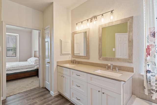23 Murmuring Creek Pl, The Woodlands, TX 77385 - ensuite bathroom featuring double vanity and wood finished floors