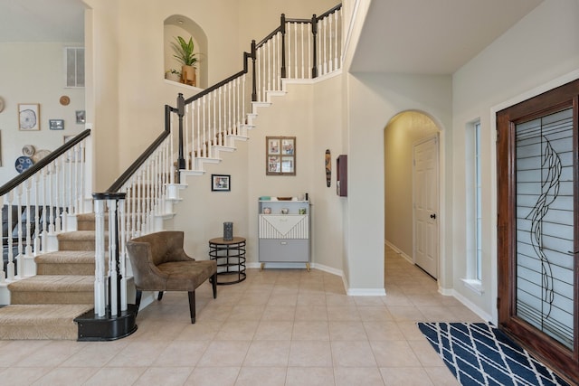23 Murmuring Creek Pl, The Woodlands, TX 77385 - tiled foyer entrance featuring stairs, arched walkways, and a high ceiling