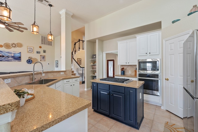 23 Murmuring Creek Pl, The Woodlands, TX 77385 - kitchen with stainless steel appliances, a kitchen island, tasteful backsplash, and white cabinetry