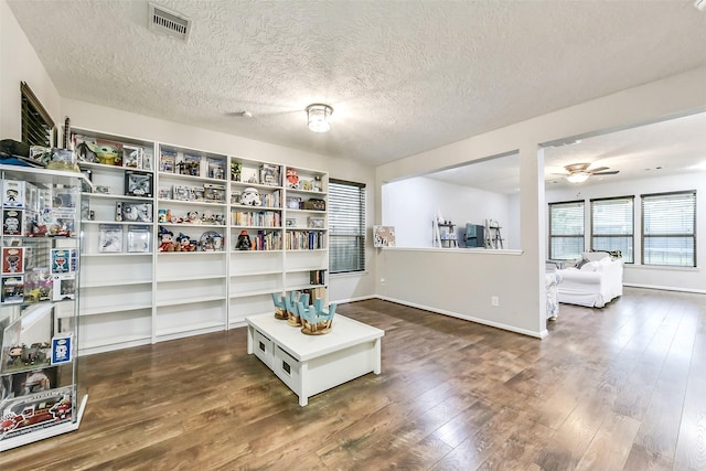 10147 Cimarron Canyon Ln, Magnolia, TX 77354 - living area with dark wood-style flooring, a ceiling fan, and a textured ceiling