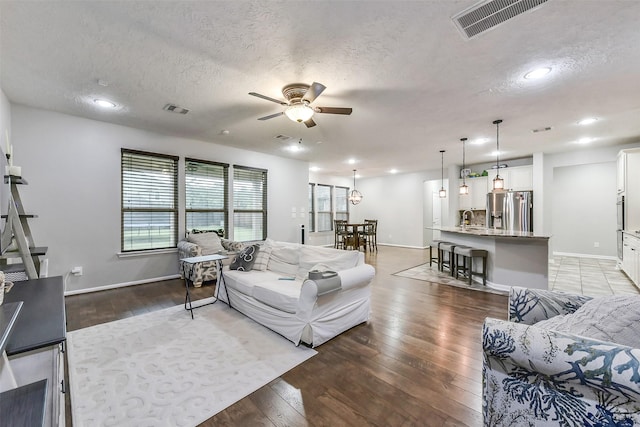 10147 Cimarron Canyon Ln, Magnolia, TX 77354 - living room featuring a ceiling fan, a textured ceiling, light wood-style floors, and recessed lighting
