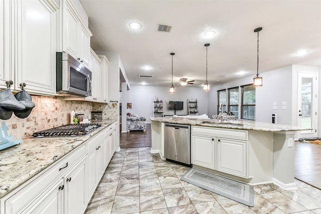 10147 Cimarron Canyon Ln, Magnolia, TX 77354 - kitchen featuring appliances with stainless steel finishes, backsplash, white cabinets, recessed lighting, and decorative light fixtures
