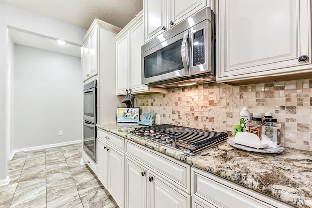 10147 Cimarron Canyon Ln, Magnolia, TX 77354 - kitchen with stainless steel appliances, white cabinets, light stone counters, backsplash, and recessed lighting