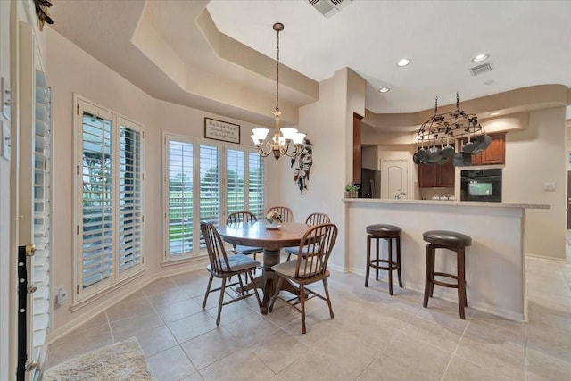 2316 Flagship Ct, League City, TX 77573 - dining space with a chandelier, a tray ceiling, light tile patterned floors, and recessed lighting