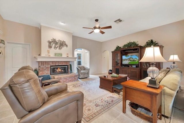 2316 Flagship Ct, League City, TX 77573 - living area featuring arched walkways, ceiling fan, a fireplace, and light tile patterned flooring