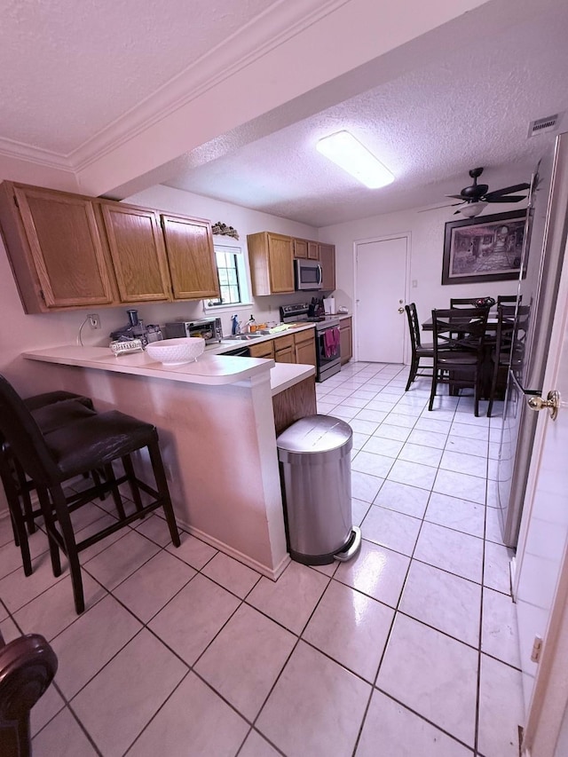 7402 Burkridge Dr, Houston, TX 77041 - kitchen featuring stainless steel appliances, a textured ceiling, a peninsula, light countertops, and light tile patterned floors