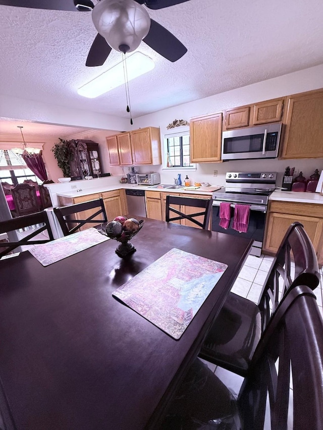 7402 Burkridge Dr, Houston, TX 77041 - kitchen featuring stainless steel appliances, a textured ceiling, light countertops, a ceiling fan, and a peninsula