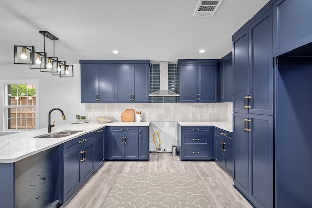 6935 Palmetto St, Houston, TX 77087 - kitchen with wall chimney exhaust hood, a peninsula, backsplash, light wood-style floors, and recessed lighting
