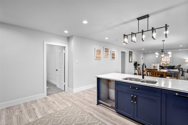 6935 Palmetto St, Houston, TX 77087 - kitchen featuring blue cabinets, recessed lighting, light wood-type flooring, hanging light fixtures, and open floor plan