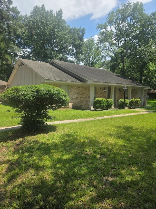 26718 Eastwood Dr, Cat Spring, TX 77386 - view of front of house featuring a front lawn, a shingled roof, and brick siding