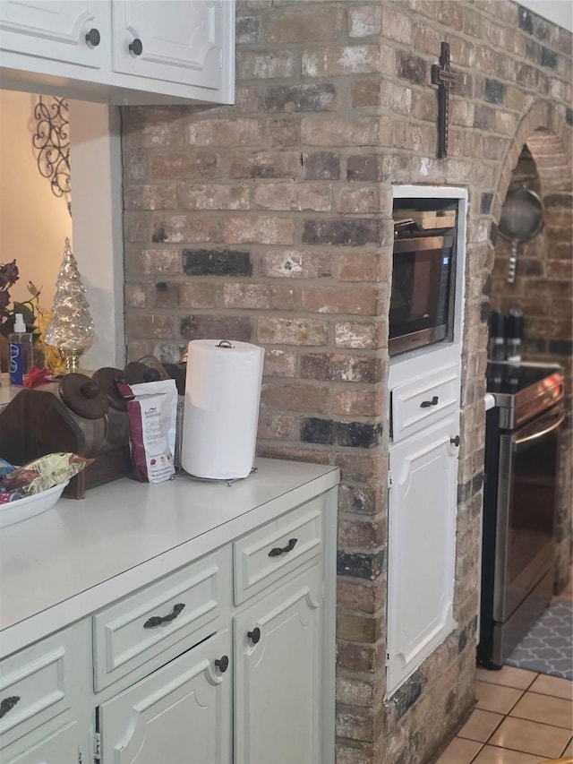 26718 Eastwood Dr, Cat Spring, TX 77386 - kitchen with appliances with stainless steel finishes, light countertops, light tile patterned floors, and white cabinetry