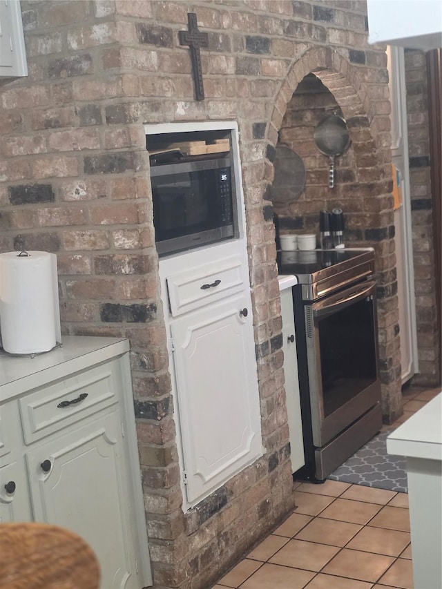 26718 Eastwood Dr, Cat Spring, TX 77386 - kitchen featuring stainless steel appliances, light tile patterned floors, white cabinets, and light countertops