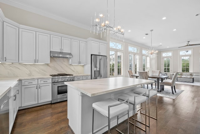 1801 Ashland St, Houston, TX 77008 - kitchen featuring stainless steel appliances, under cabinet range hood, a chandelier, recessed lighting, and ornamental molding