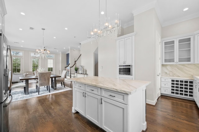 1801 Ashland St, Houston, TX 77008 - kitchen featuring a chandelier, freestanding refrigerator, white cabinets, ornamental molding, and dark wood-style floors