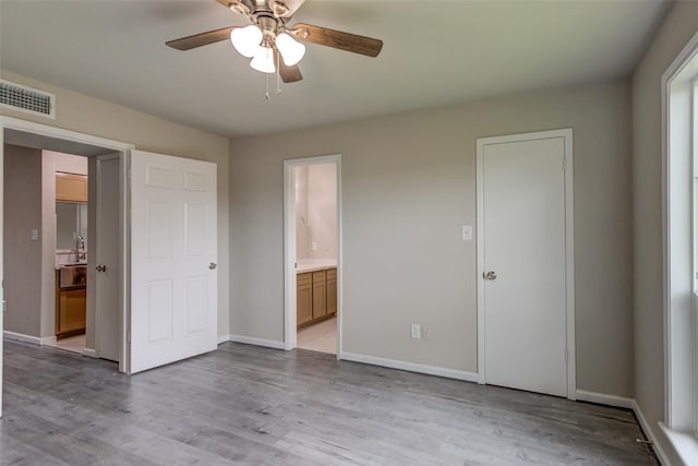 3300 Pebblebrook Dr Unit 15, Seabrook, TX 77586 - unfurnished bedroom with connected bathroom, light wood-type flooring, and a ceiling fan