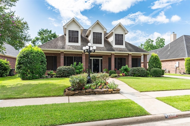 2603 Piney Woods Dr, Pearland, TX 77581 - cape cod-style house with brick siding, a front lawn, and roof with shingles