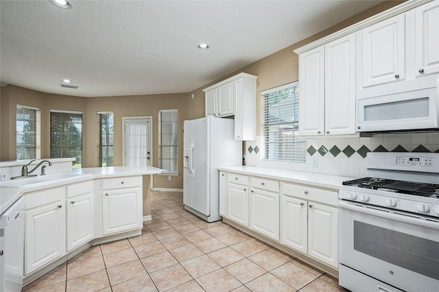 2603 Piney Woods Dr, Pearland, TX 77581 - kitchen with white appliances, white cabinets, decorative backsplash, light countertops, and light tile patterned flooring