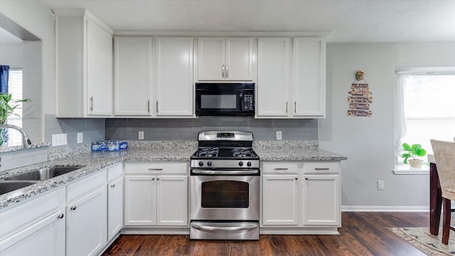 2319 Blue Reef Dr, Katy, TX 77449 - kitchen with black microwave, stainless steel gas range oven, plenty of natural light, and backsplash