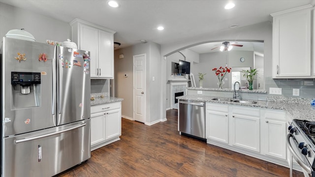 2319 Blue Reef Dr, Katy, TX 77449 - kitchen featuring appliances with stainless steel finishes, a ceiling fan, decorative backsplash, white cabinetry, and light stone countertops