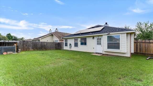 2319 Blue Reef Dr, Katy, TX 77449 - back of house featuring a fenced backyard, roof mounted solar panels, and roof with shingles