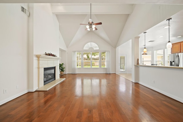 4802 N Pine Brook Way, Houston, TX 77059 - unfurnished living room with a ceiling fan, plenty of natural light, a glass covered fireplace, high vaulted ceiling, and wood finished floors