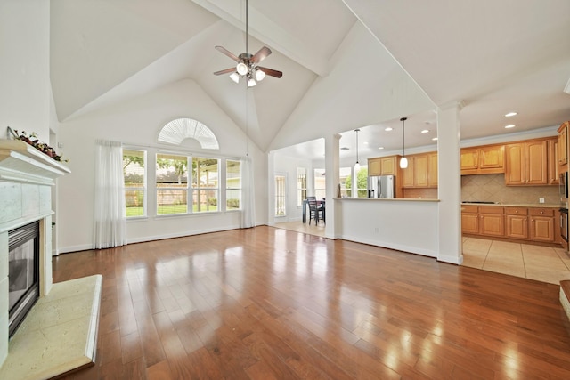 4802 N Pine Brook Way, Houston, TX 77059 - unfurnished living room with a ceiling fan, a tile fireplace, high vaulted ceiling, light wood-style floors, and recessed lighting