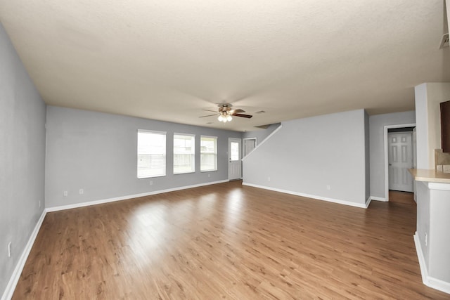 9914 Swallow Dr, Conroe, TX 77385 - unfurnished living room with a ceiling fan, wood finished floors, and a textured ceiling