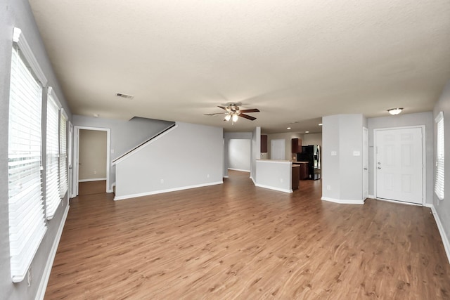 9914 Swallow Dr, Conroe, TX 77385 - unfurnished living room with a ceiling fan, wood finished floors, and stairs