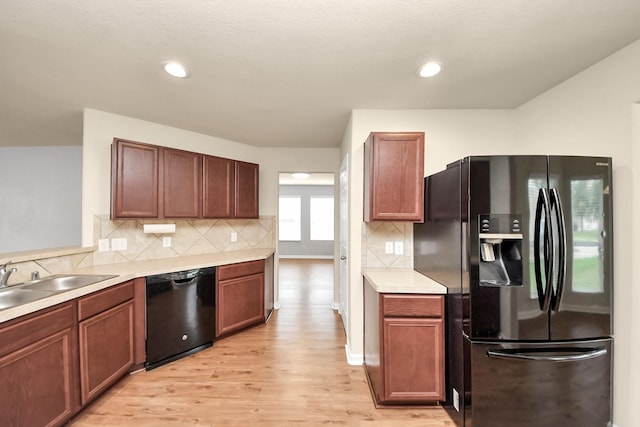 9914 Swallow Dr, Conroe, TX 77385 - kitchen featuring black appliances, light wood-style floors, light countertops, backsplash, and recessed lighting
