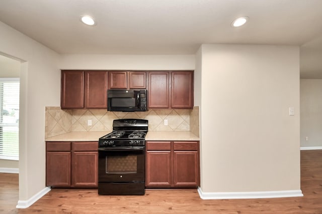 9914 Swallow Dr, Conroe, TX 77385 - kitchen featuring black appliances, light countertops, backsplash, light wood-style flooring, and recessed lighting
