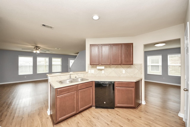 9914 Swallow Dr, Conroe, TX 77385 - kitchen with black dishwasher, a ceiling fan, light wood-type flooring, light countertops, and tasteful backsplash