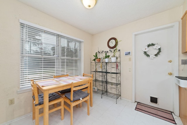 12611 Bexhill Dr, Houston, TX 77065 - dining area featuring baseboards and a textured ceiling