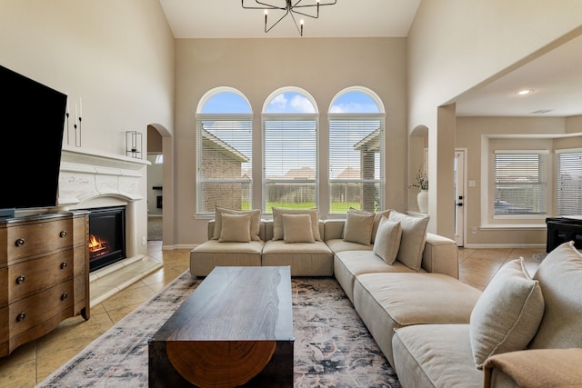 20314 Tarpon Bay Ln, Cypress, TX 77433 - living room with a high ceiling, plenty of natural light, light tile patterned flooring, arched walkways, and a chandelier