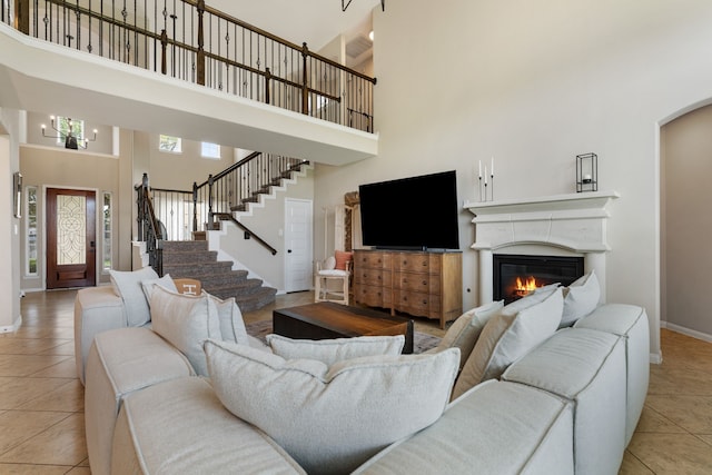 20314 Tarpon Bay Ln, Cypress, TX 77433 - living room with a towering ceiling, light tile patterned floors, a glass covered fireplace, stairway, and arched walkways