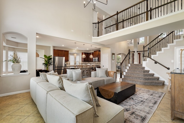 20314 Tarpon Bay Ln, Cypress, TX 77433 - living area with a towering ceiling, stairs, light tile patterned floors, and a chandelier