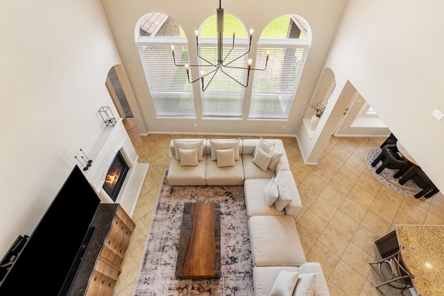 20314 Tarpon Bay Ln, Cypress, TX 77433 - tiled living room with a warm lit fireplace, a high ceiling, and a chandelier