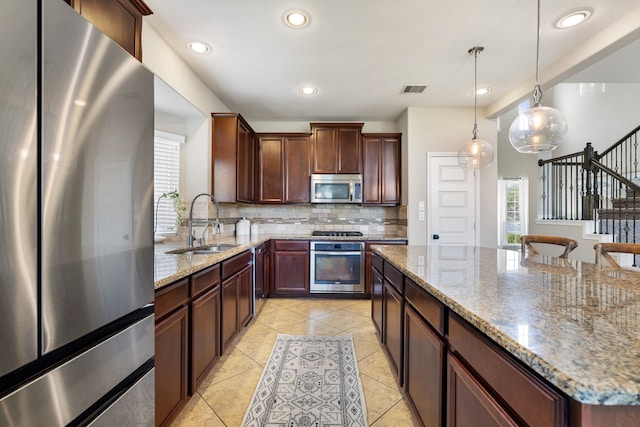 20314 Tarpon Bay Ln, Cypress, TX 77433 - kitchen with appliances with stainless steel finishes, backsplash, light stone counters, hanging light fixtures, and recessed lighting