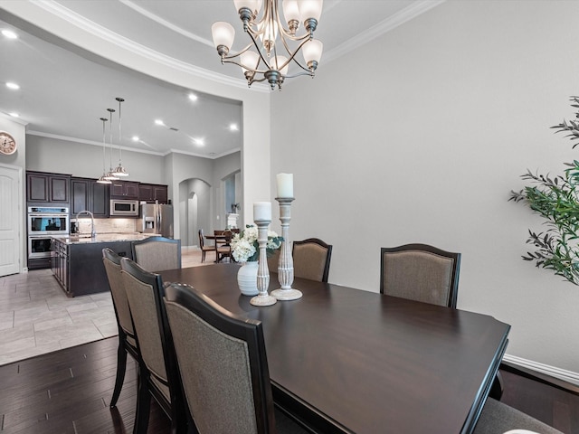 4623 Bisontine Bay Ln, Rosharon, TX 77583 - dining room featuring crown molding, arched walkways, recessed lighting, wood finished floors, and a chandelier