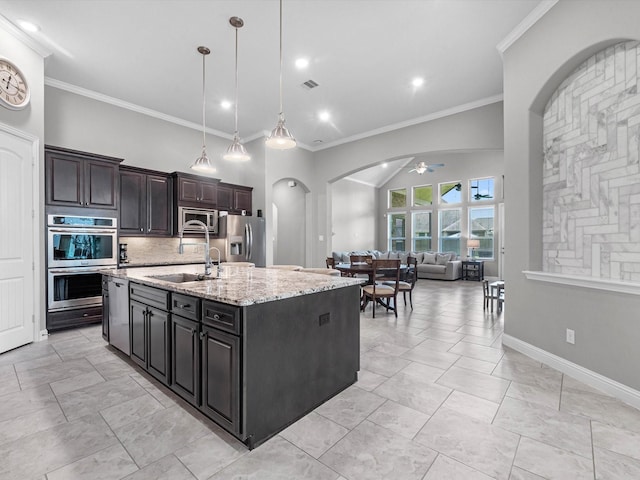 4623 Bisontine Bay Ln, Rosharon, TX 77583 - kitchen with stainless steel appliances, arched walkways, ceiling fan, an island with sink, and open floor plan