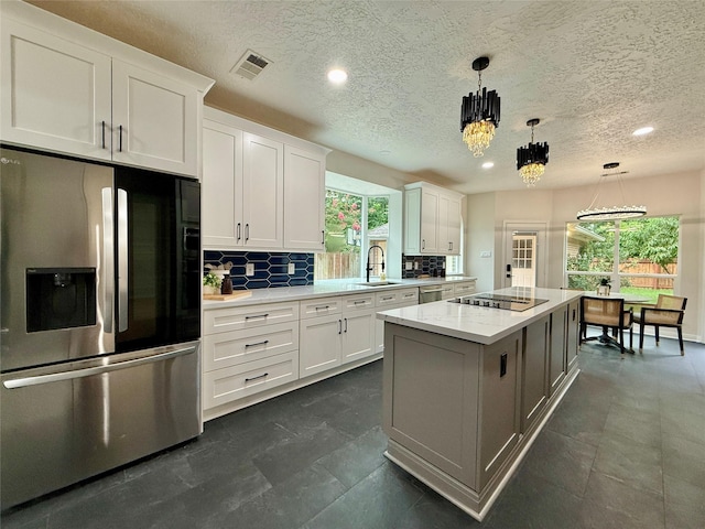 19 Pebble Hollow Ct, The Woodlands, TX 77381 - kitchen featuring appliances with stainless steel finishes, white cabinets, a center island, backsplash, and recessed lighting
