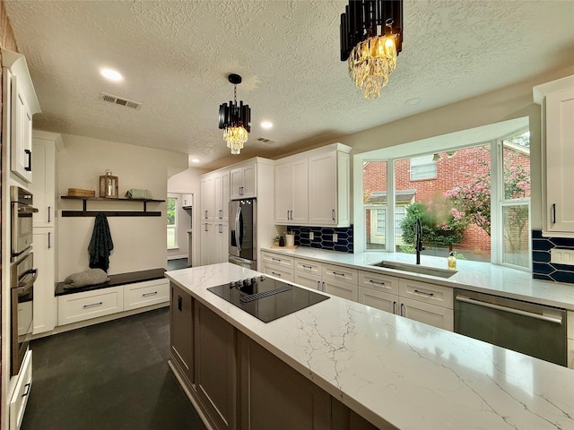 19 Pebble Hollow Ct, The Woodlands, TX 77381 - kitchen with appliances with stainless steel finishes, a textured ceiling, tasteful backsplash, white cabinets, and a chandelier